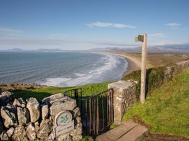 A beach view with a gate and signpost at Alet-y-Mor in Talybont