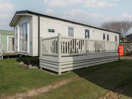 A caravan with a deck and outdoor seating at Gold Caravan (203) Talybont