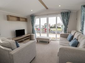 A living room with two sofas and a television at Gold Caravan (203) Talybont