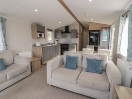 A living room with sofa and kitchen area at Gold Caravan (203) Talybont