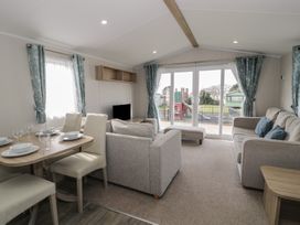 A living room with a dining area and sofa at Gold Caravan (203) Talybont