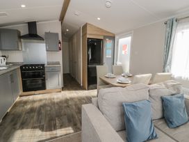 A kitchen with dining table and chairs at Gold Caravan (203) Talybont
