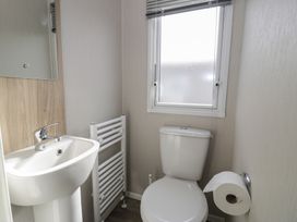A bathroom with a sink, toilet, and towel rail at Gold Caravan (203) Talybont