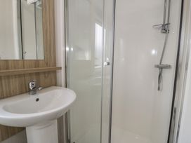 A bathroom with a shower and sink at Gold Caravan (203) Talybont