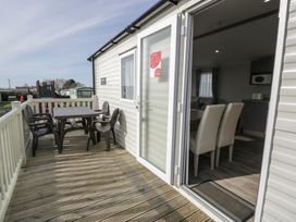 A deck with a table and chairs at Gold Caravan (203) Talybont