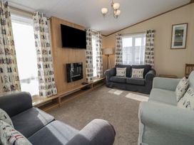 A living room with sofas and a TV at Gold Lodge (201) Talybont