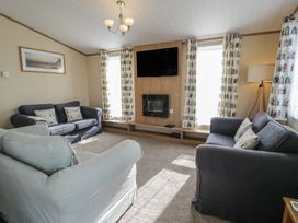 A living room with sofas, a television, and a fireplace at Gold Lodge (201) Talybont