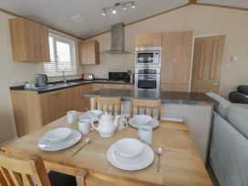 A kitchen with a dining table set at Gold Lodge (201) Talybont