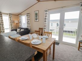 A living room with a dining table and sofa at Gold Lodge (201) Talybont