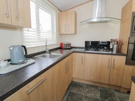A kitchen with a sink and gas hob at Gold Lodge (201) Talybont