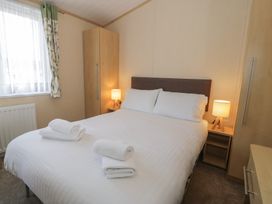 A bedroom with a bed and side tables at Gold Lodge (201) Talybont