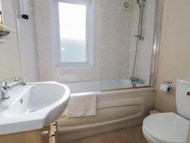 A bathroom featuring a bathtub, sink, and toilet at Gold Lodge (201) Talybont