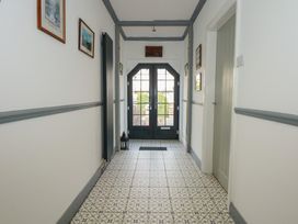 A hallway with patterned tile floor and dark framed glass door at Bryn-Y-Glyn in Penrhyn Bay