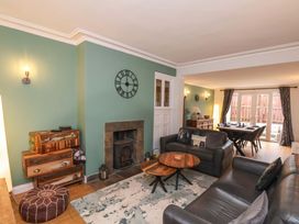 A living room with a sofa, table, and fireplace at Falcon's Nest in Whitby