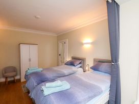 A bedroom with two beds and a wardrobe at Falcon's Nest in Whitby