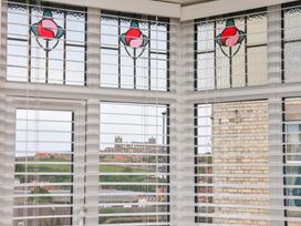A conservatory with stained glass windows and a view outside at Falcon's Nest in Whitby