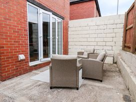 An outdoor patio area with armchairs and a table at Falcon's Nest in Whitby
