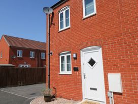 The exterior of a red brick house with white door and windows and a satellite dish at Ty Bach Twt Llanelli