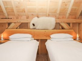 A bedroom with two beds and a wooden headboard at Pucklechurch Kingsteignton