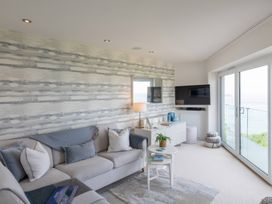 A living room with a sofa and television at 7 Atlantic Watch in Carbis Bay
