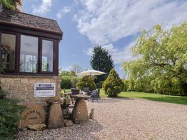 An outdoor area with stone building corner and garden furniture under umbrella at Yeabridge Farm Mosterton near Beaminster