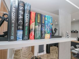 A shelf with books supported by anchor bookends and a small decorative figurine in a room at Porto Brid in Bridlington