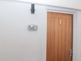 A wooden door with number 1 and a sign reading Flat 1 Cliff Street at Porto Brid in Bridlington