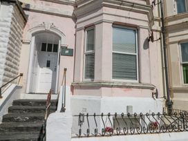The front entrance of a building with stairs leading to a white door numbered 11 and a large window with blinds at Porto Brid in Bridlington
