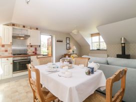 A kitchen and dining area with a table set for tea and a sitting area with a sofa at The Hayloft in Lostwithiel