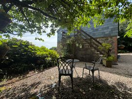 A garden with two chairs and a table at The Hayloft in Lostwithiel