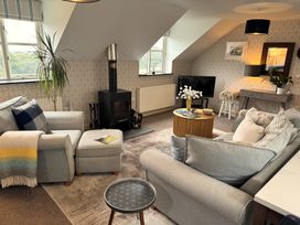 A living room with seating and a stove at The Hayloft in Lostwithiel