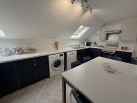 A kitchen with a washing machine and a table at The Hayloft in Lostwithiel