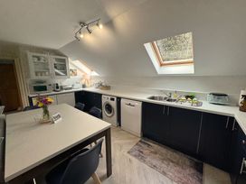 A kitchen with appliances and a dining table at The Hayloft in Lostwithiel