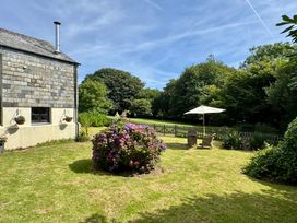 A garden with chairs and an umbrella at The Mill in Lostwithiel