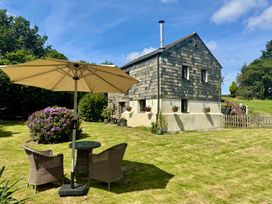 A garden with a table and chairs under an umbrella at The Mill in Lostwithiel