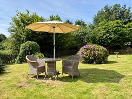 A garden with a table and chairs under an umbrella at The Mill in Lostwithiel