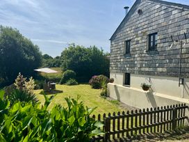 A garden with a house and seating area at The Mill in Lostwithiel