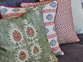 Four decorative cushions with different patterns on a dark fabric surface at The Stables in Galteemore Farm in Avebury near Marlborough