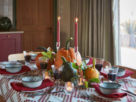 A dining table set with bowls glasses red napkins pumpkins candles and leaves at The Stables in Galteemore Farm in Avebury near Marlborough