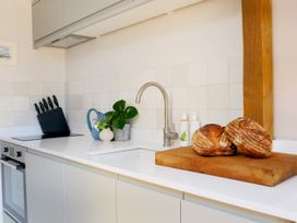 A kitchen counter with a cutting board holding two loaves of bread at The Stables in Galteemore Farm in Avebury near Marlborough