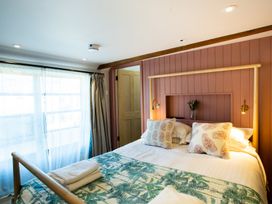 A bedroom with a bed pillows and towels near a window at The Stables in Galteemore Farm in Avebury near Marlborough