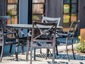 An outdoor patio area with a round table and metal chairs at The Stables in Galteemore Farm in Avebury near Marlborough