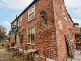 The exterior of a brick building with wooden tables and chairs outside at The Star Inn in North Dalton near Great Driffield