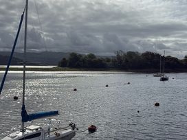 A view of boats on water with trees in the background at Harbour Escape Porthmadog