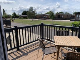 An outdoor seating area with table and chairs at Longdon Lodge in Wickhamford near Evesham