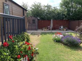 A garden with a shed and seating area at Longdon Lodge Wickhamford near Evesham