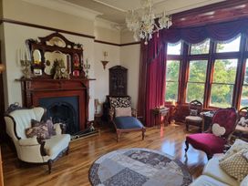 A living room with a fireplace and large windows at Ashleigh House