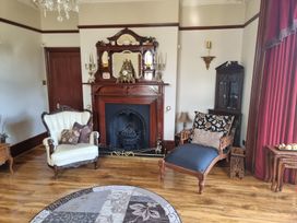 A living room with a fireplace and seating at Ashleigh House
