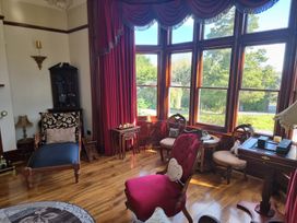 A sitting room with furniture and large windows at Ashleigh House