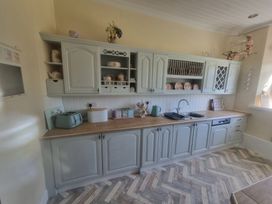 A kitchen with cabinets, sink, and countertop at Ashleigh House